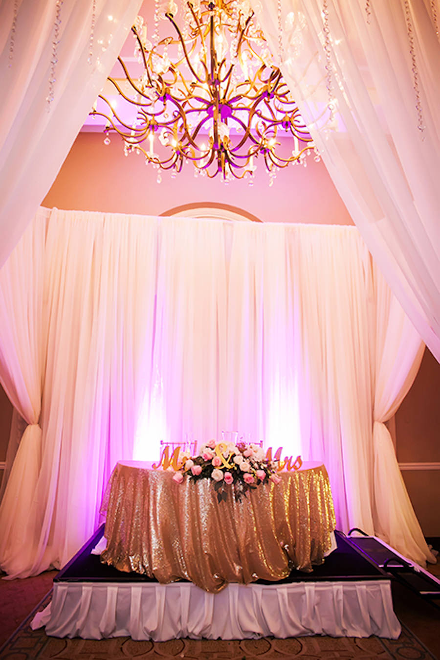 Pink and Gold Wedding Sweetheart Table with Gold Specialty Linen and Light Pink Uplighting at St Pete Wedding Venue The Don Cesar | St Pete Wedding Photographer Limelight Photography
