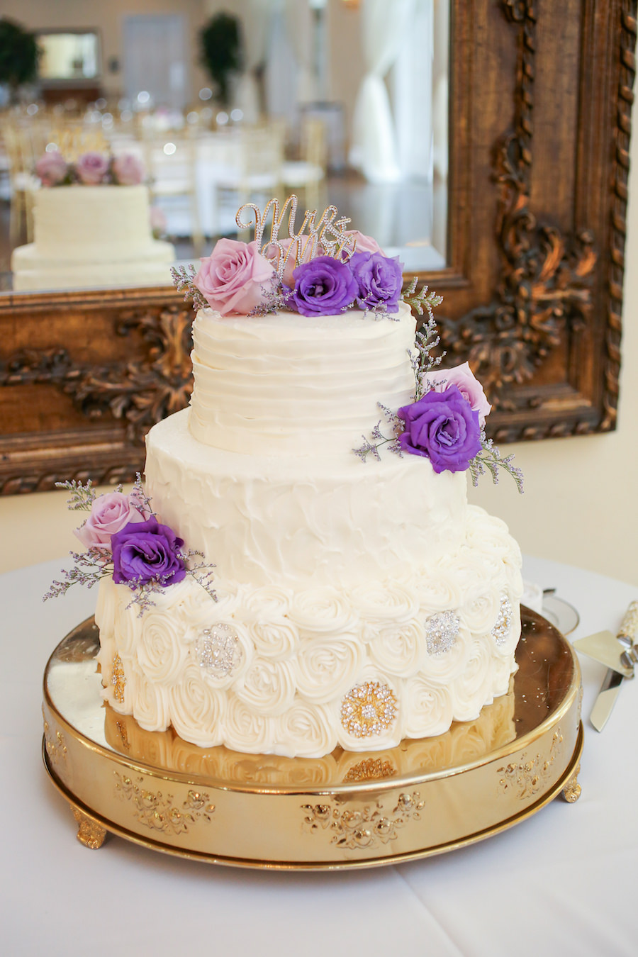 Three Tiered White Round Wedding Cake with Purple and Pink Rose Accent on Gold Cake Stand by Tampa Wedding Cake Shop Olympia Catering