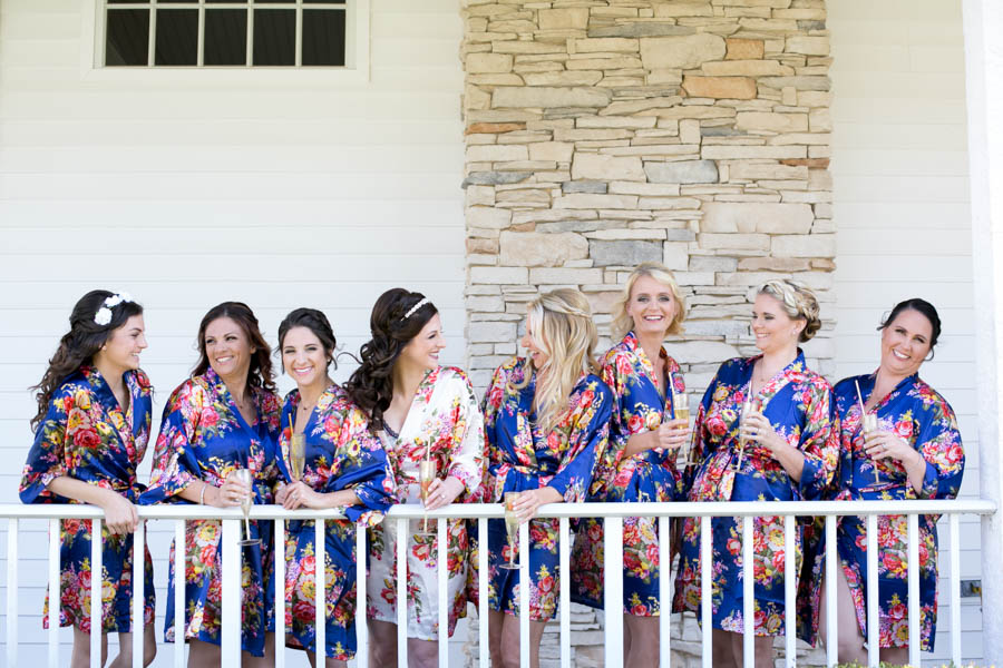 Bride and Bridesmaids Drinking Champagne on Wedding Day in Navy Blue and White Floral Robes | Tampa Bay Wedding Videographer Hatfield Productions