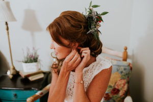 Bride Getting Ready Putting on Jewelry with Flowers in Hair | Retro Vintage Boho Wedding Inspiration | Tampa Wedding Florist Northside Florist
