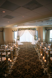 White and Gold Wedding Reception Decor and Inspiration with Ivory Linen and Roses Arch and Gold Chiavari Chairs with White Rose Petals and Gold Candles Along Aisle | Modern Elegant Downtown Tampa Wedding Venue The Tampa Club | Tampa Florist Northside Florist | Rentals A Chair Affair | Linens Gabro Event Services | Tampa Bay Wedding Photographer Carrie Wildes Photography