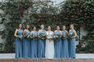 Bridal Wedding Portrait in Sleeveless Ivory Lace Wedding Dress and Bridesmaids in Dusty Blue One Shoulder Floor Length Bridesmaids Dress | Ivory, Purple and Greenery Wedding Bouquets with Eucalyptus | Tampa Bay Wedding Florist Wonderland Floral Art |Tampa Bay Wedding Videographer Bonnie Newman Creative