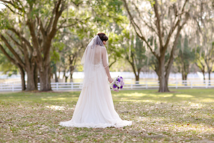 Outdoor Bridal Wedding Portrait in Maggie Sottero Wedding Dress at Tampa Bay Wedding Venue The Lange Farm | Purple, Ivory and Lilac Roses Bridal Wedding Bouquet | Tampa Wedding Florist Northside Florist