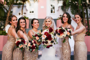 Florida Bridal Wedding Party Portrait at Don CeSar Hotel in St. Pete Beach | Ivory Strapless Drop Waist Pronovias Wedding Dress and Champagne, Gold Bridesmaids Dresses with Burgundy and Pink Floral Bouquets | Pronovias Wedding Dress | Tampa Wedding Photographer Limelight Photography