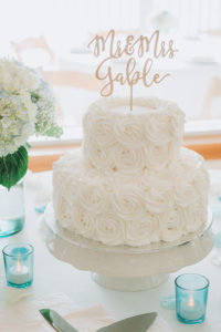 Two Tiered White Wedding Cake with Floral Icing Design and Custom Cake Topper