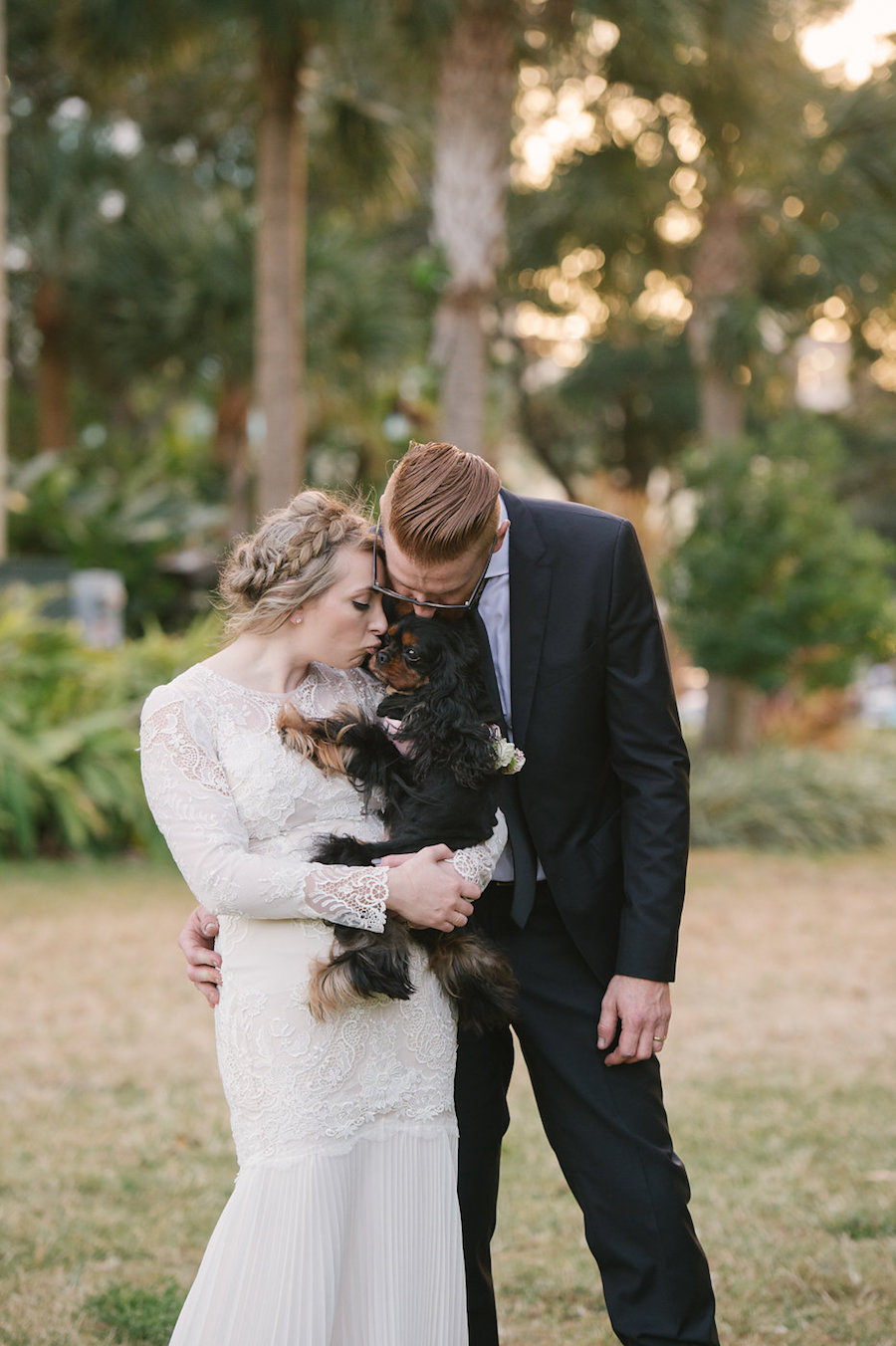 Bride and Groom Florida Wedding Portrait with Puppy in Long Sleeve Lace Wedding Dress with Lace Veil and Groom in Tuxedo