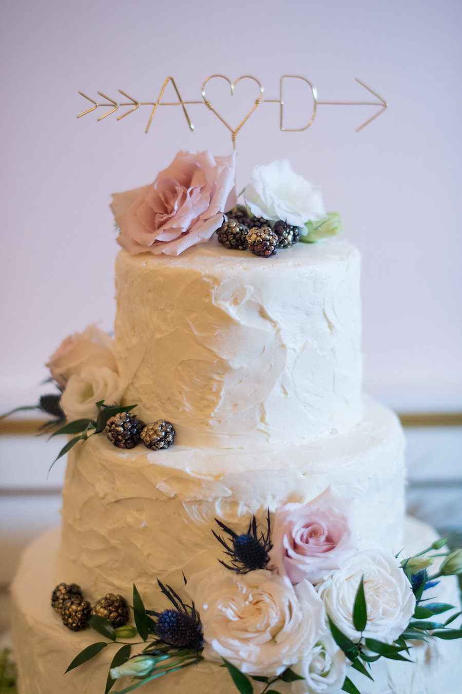 Three Tiered White Wedding Cake with Fresh Rose Floral Accent with Gold Dipped Blackberries and Metal Initial Cake Topper from Olympia Catering