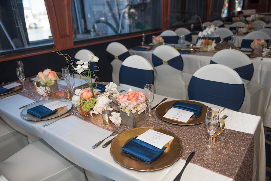 Nautical Inspired Wedding Reception with White Chair Covers and Navy Bows with Gold Charger Plates | Tampa Bay Waterfront Wedding Venue Yacht StarShip