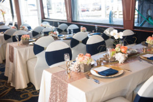 Nautical Inspired Wedding Reception with White Chair Covers and Navy Bows with Gold Charger Plates and Gold Sequin Table Runners | Simple Nautical Wedding Decor | Tampa Bay Waterfront Wedding Venue Yacht StarShip