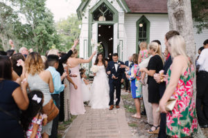 Wedding Ceremony Exit Portrait with Flower Petal Toss at Andrews Memorial Chapel with White Rose Petals | Tampa Bay Wedding