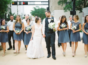 Outdoor Downtown Wedding Party Portrait with White Lace Trumpet Wedding Dress Mismatched Gray Short Bridesmaid Dresses and White and Greenery Bouquets | Downtown Tampa Wedding
