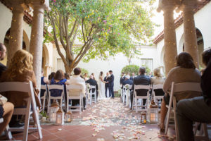 Wedding Ceremony Decor with Rose Petal Strewn Aisle with White and Gold Candle Holders and Folding Chairs at Modern Elegant Blush Wedding | Tampa Bay Photographer Kristen Marie Photography | St Petersburg Wedding Venue Museum of Fine Arts