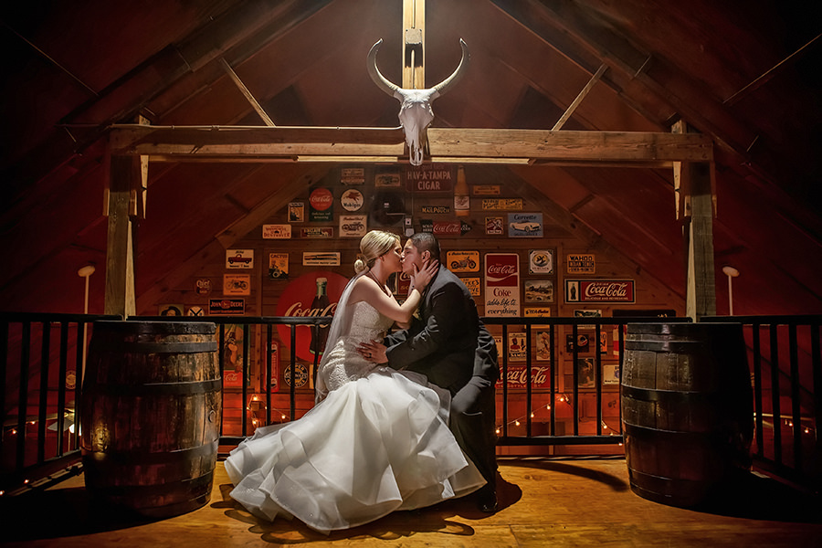 Bride and Groom Portrait in Barn with Vintage Signs Rustic Barrels | Tampa Bay Wedding Venue The Lange Farm | Photographer Brian C Idocks Photographics