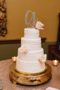 Elegant and Romantic 4-Tier Round Textured Wedding Cake from Tampa Bay Bakery A Piece of Cake on Gold Serving Platter with Blush Roses and Stylish Glitter Monogram Initial Topper