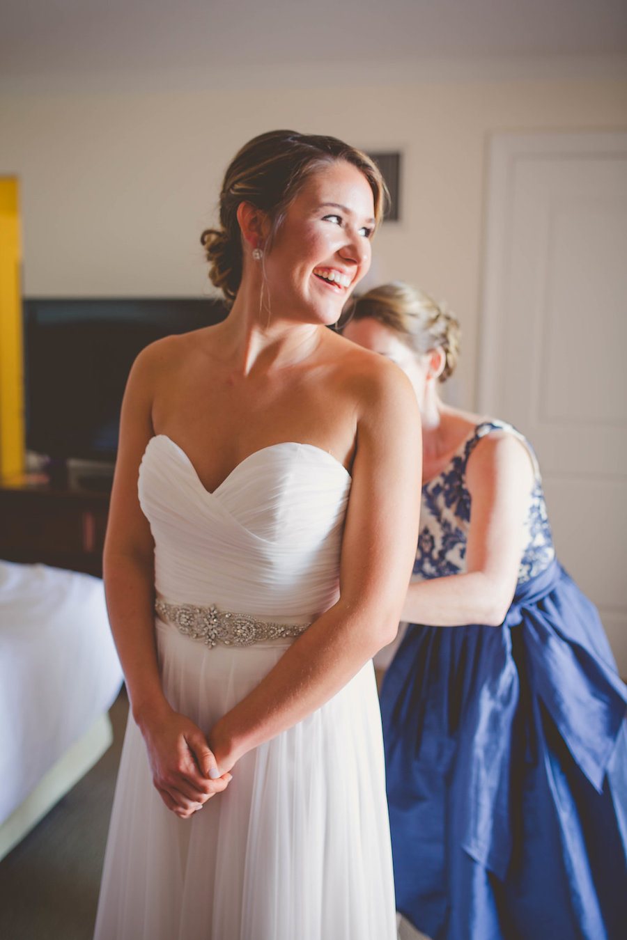 Bride Getting Dressed Portrait wearing Sweetheart Mikaella by Paloma Blanca Wedding Dress with Silver Jeweled Belt