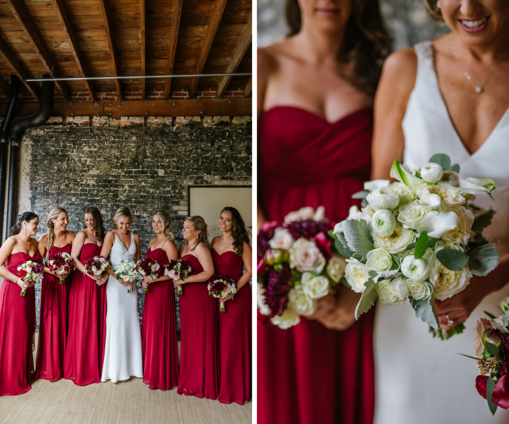 Elegant Bridal Party Portrait in Industrial Brick Wall Wedding Venue with Strapless Bordeaux Bridesmaids Dresses and Martina Liana Wedding Dress with White and Red Bouquets with Greenery