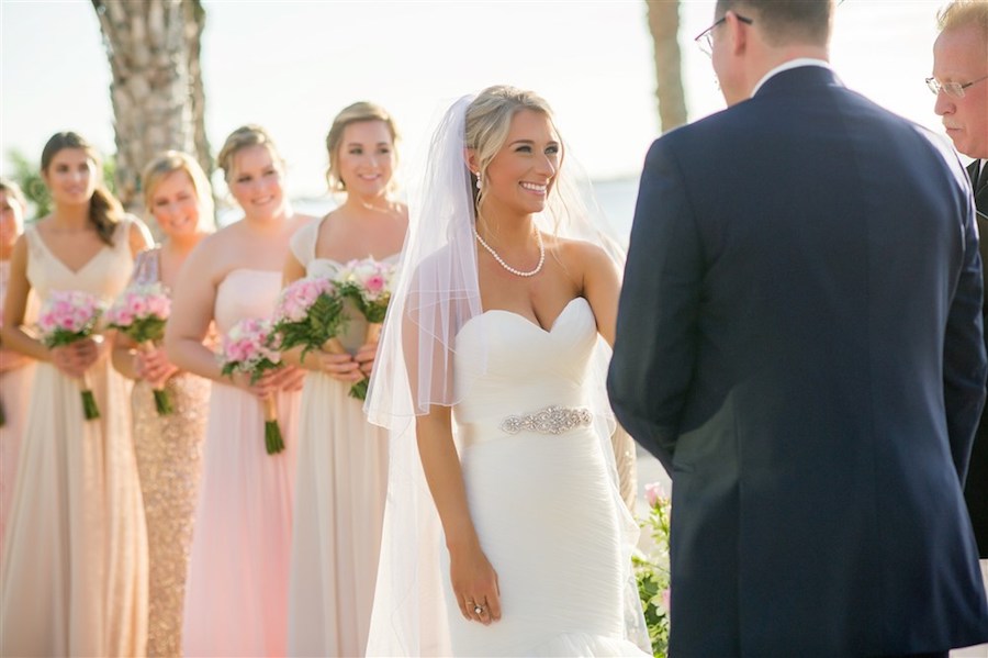 Outdoor Waterfront Wedding Ceremony Portrait with Sweetheart Dress with Silver Jeweled Belt, Long-stemmed White and Pink Bouquets with Fern Greenery and Mismatched Pink, Cream, Gold, and Sequined Bridesmaids Dresses