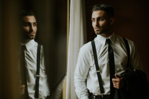 Groom Getting Ready Dramatic Portrait with Suspenders Suit and Skinny Black Tie Tampa Bay Wedding Photographer Brandi Image Photography