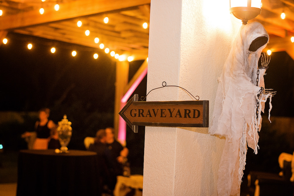 Outdoor Halloween Inspired Wedding Reception Decor with Vintage Arrow Sign and Ghost Figurine
