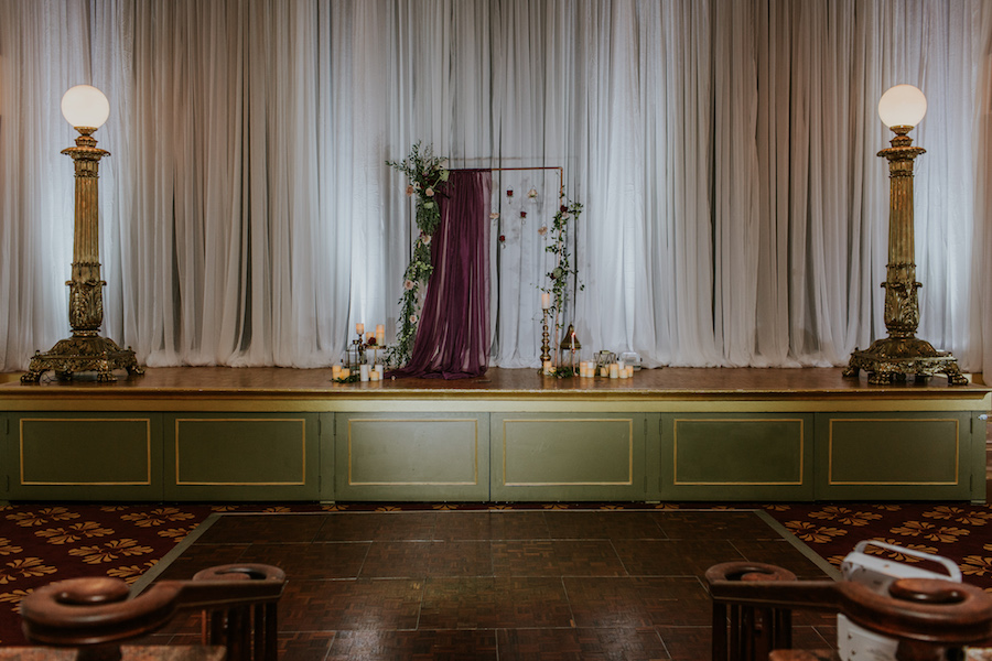 Deep Red Burgundy Wedding Ceremony Decor with Candles and Hanging Floral Rose Draped Altar Backdrop | Romantic Vintage Glam Wedding | Tampa Bay Wedding Planner Southern Glam Weddings & Events | Unique Tampa Bay Wedding Venue Safety Harbor Resort and Spa Theatre