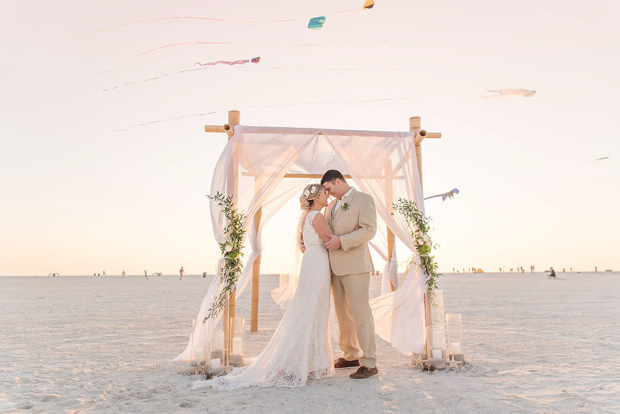 Beach Wedding Ceremony Portrait with Kites, Bamboo Wedding Arch with Drapery and Natural Beach Inspired Flowers with Greenery | St Petersburg Wedding Photographer Kristen Marie Photography
