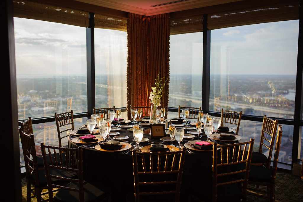 Elegant Wedding Reception with View of Downtown Tampa | Table Decor with Black Linens, Simple White Orchid Centerpiece in Tall Glass Vases, and Gold Chiavari Chairs | Tampa, Florida Wedding Venue The Tampa Club