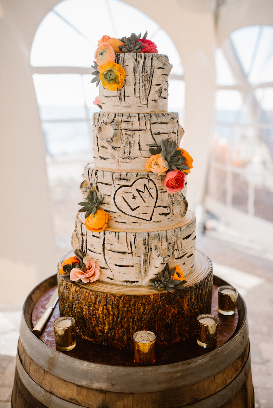 Four Tier Round Birch Bark Wedding Cake with Initials and Pink and Orange Roses with Succulents on Tree Round Cakestand and Rustic Barrel