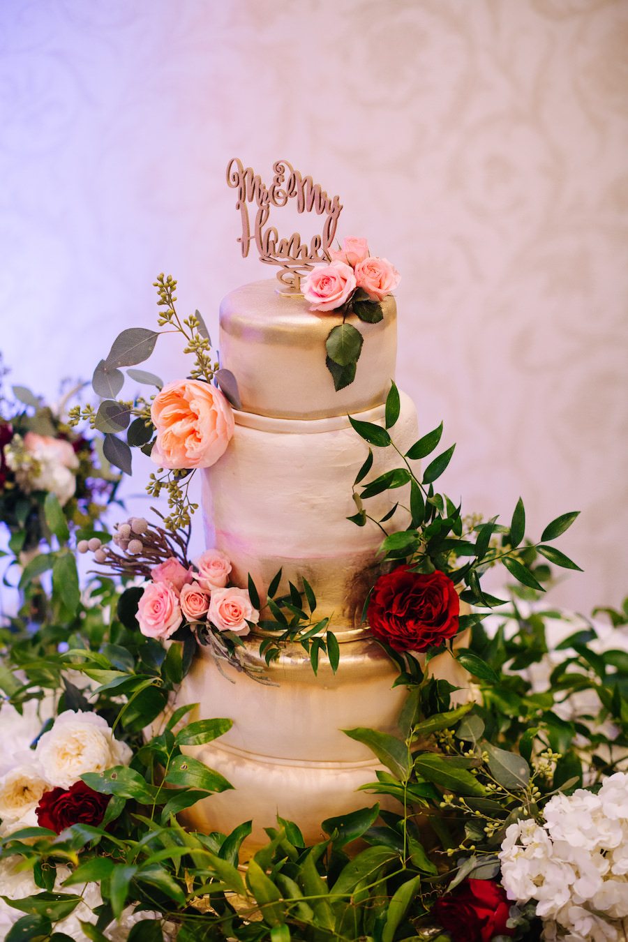 Five Tier Gold and White Wedding Cake with Blush Pink, Peach, Red, and White Roses with Greenery and Gold Mr and Mrs Cake Topper