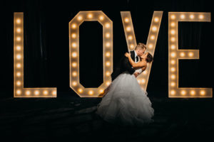 Nightime Bride and Groom Wedding Portrait in front of Love Sign by Tampa Bay Wedding Photographer Rad Red Creative