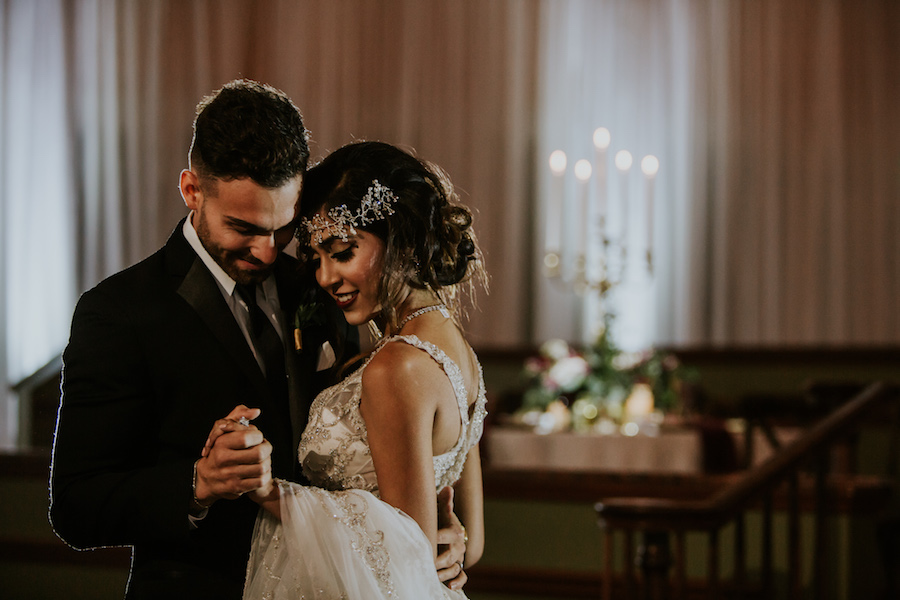 Vintage Glam 1920s Groom and Bride First Dance Portrait with Deep V-Neck Plunging Open Back Wedding Dress with Beading | Tampa Bay Wedding Photographer Brandi Image Photography | Romantic Vintage Glam Wedding | Unique Tampa Bay Wedding Venue Safety Harbor Resort and Spa Theatre