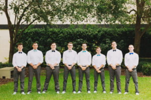Outdoor Garden Groomsmen Wedding Portrait with White Shirts, Gray Pants, and Blue and Gray Bowties
