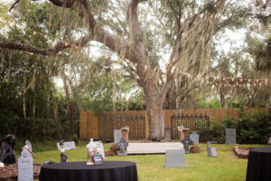 Halloween Themed Wedding Reception Decor with Tombstones and Black Linens and String Lights