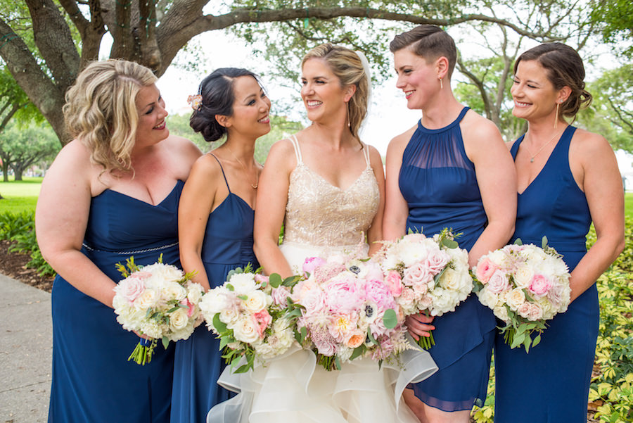 Outdoor Garden Bridal Portrait with Cream Sequin Ball Gown Wedding Dress and Blue Mismatched Bridesmaids Dresses and Pink Peony and White Rose Bouquets with Greenery