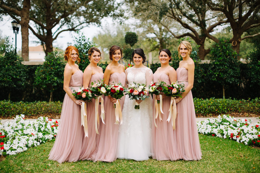 Outdoor Garden Bridal Party Portrait with White, Red, and Blush Rose Bouquets with Long Ribbon, Monique Lhuillier Strapless Tulle Bridesmaids Dresses, and A-Line Princess Lace Sleeved Sophia Tolli Wedding Dress | Tampa Bay Wedding Venue The Palmetto Club