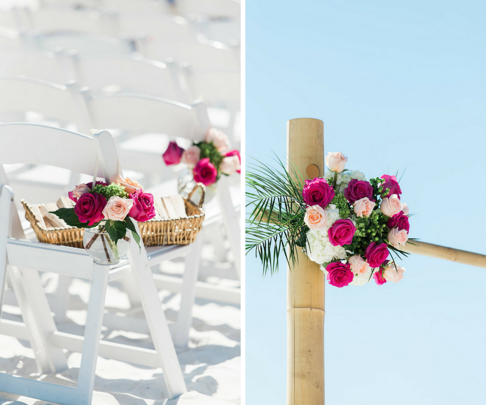 Wedding Ceremony Decor with Fuchsia, Magenta and Blush Roses and Flowers with Tropical Greenery in Glass Vases and Bamboo Ceremony Arch on White Folding Chairs