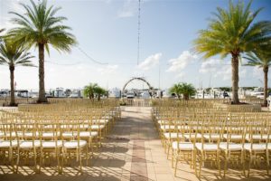 Waterfront Wedding Ceremony Decor at South Tampa Wedding Venue Westshore Yacht Club with Floral Arches and Gold Chiavari Chairs