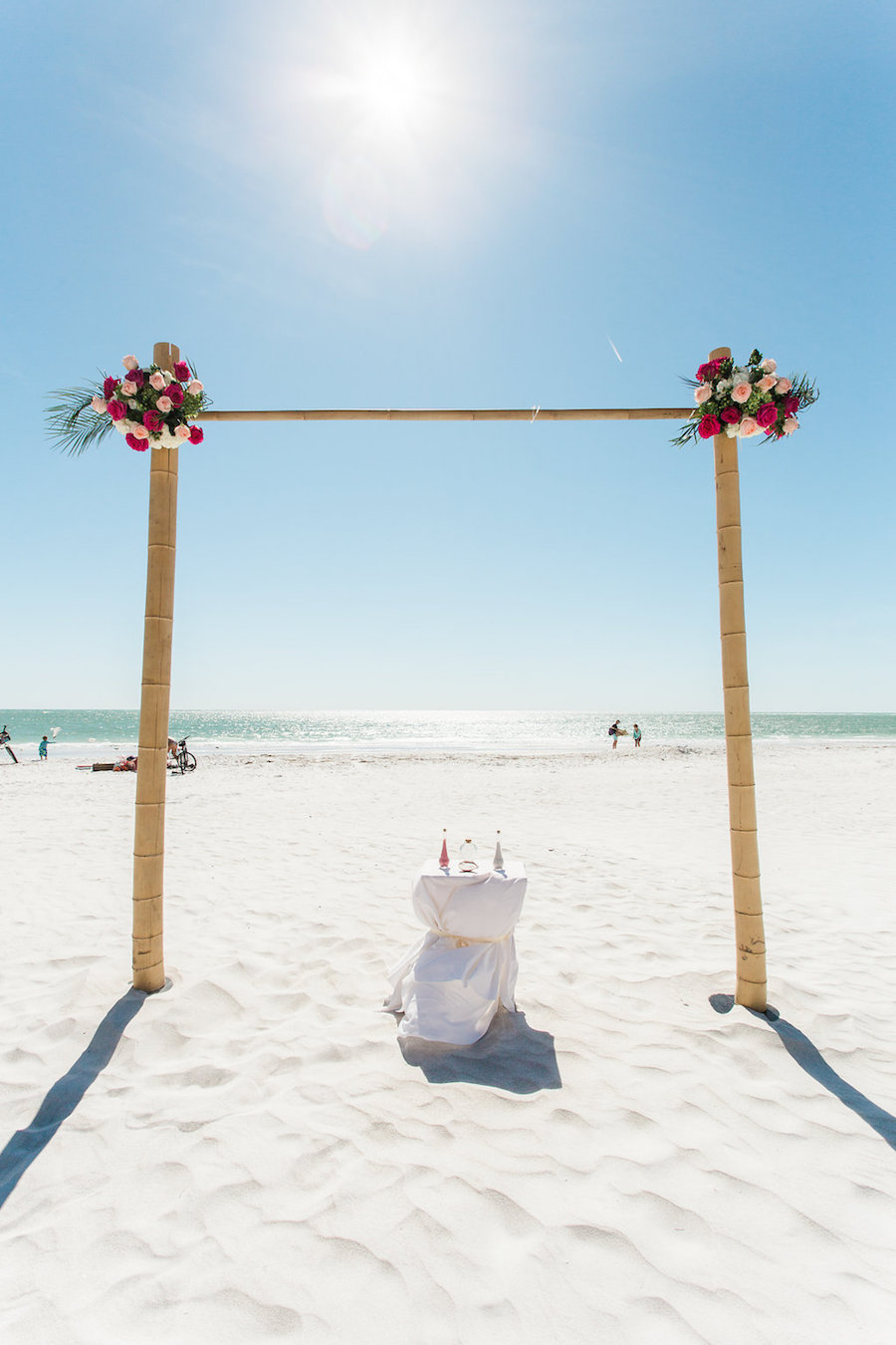 Siesta Key Beach Wedding Ceremony Decor with Tropical Fuchsia and Pink Rose Flowers on Bamboo Arch | Sarasota Wedding Planner Parties A La Carte