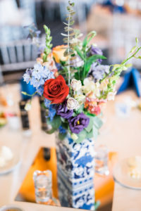 Blue Vintage Asian Inspired Wedding Decor with Colorful Orange and Purple Flower Centerpieces in Antique Vase