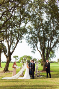 Outdoor Garden Wedding Ceremony Portrait with Bride with Extended Train and Driftwood White Floral Wedding Arch | Tampa Bay Wedding Photographer Limelight Photography