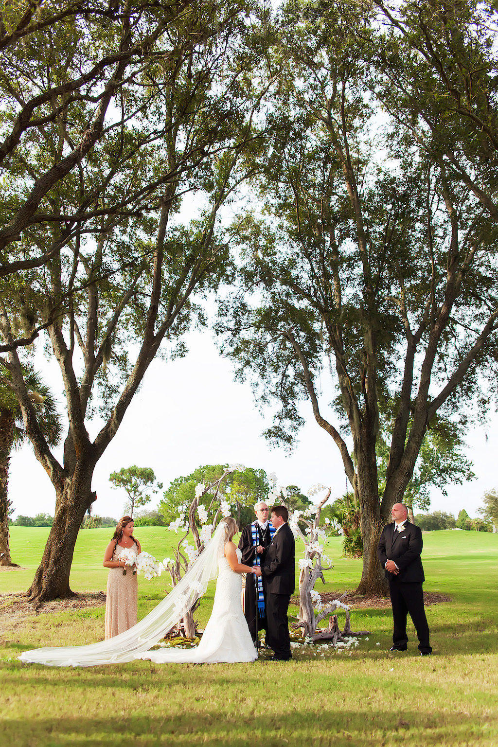 Outdoor Garden Wedding Ceremony Portrait with Bride with Cathedral Train and Driftwood White Floral Wedding Arch | Clearwater Wedding Photographer Limelight Photography | Golf Course Wedding Venue Countryside Country Club