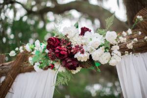 Wedding Ceremony Arch Decor with Drapery and Red Berries, Marsala and Cream Flowers, Ferns and Greenery