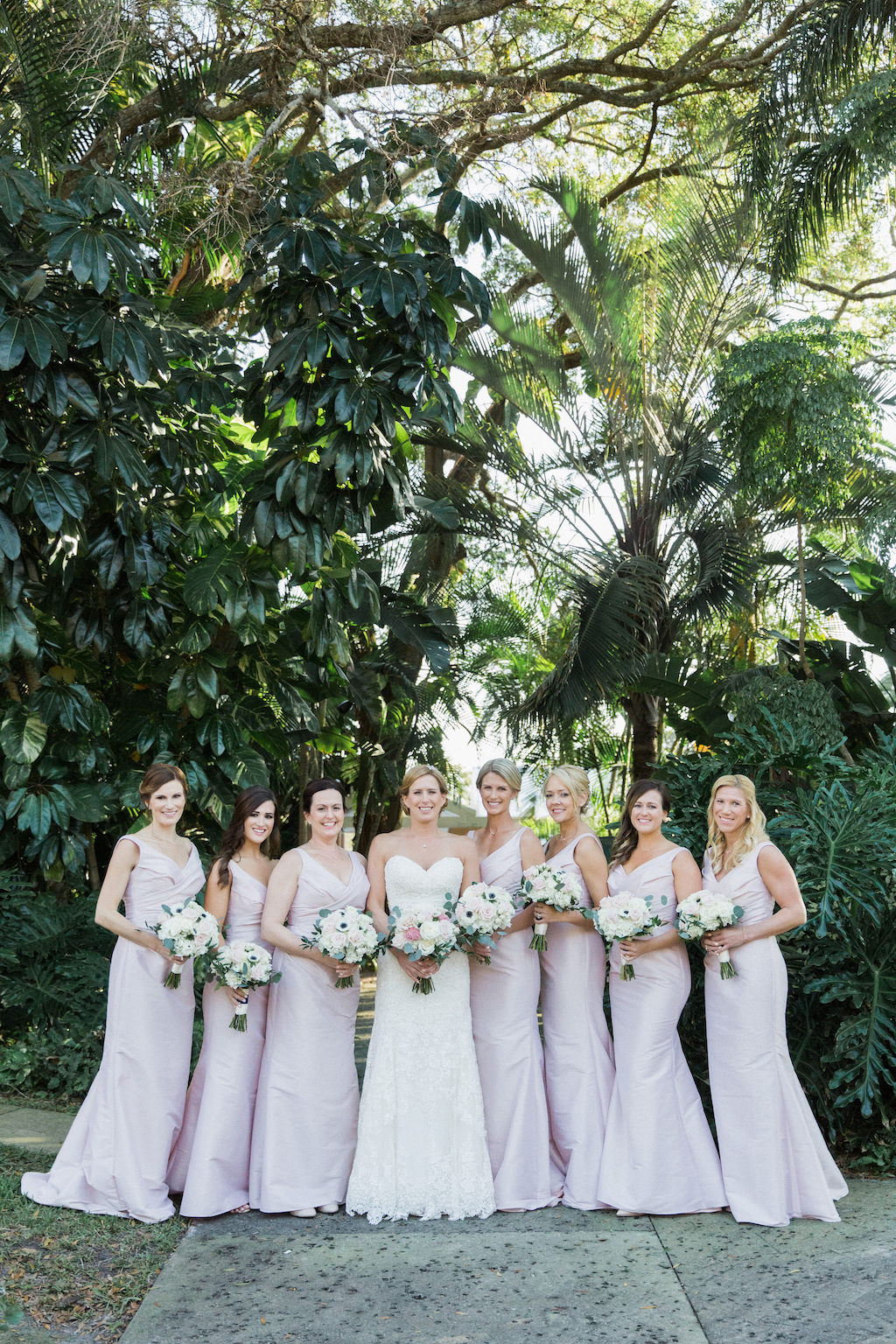 Outdoor Tropical Garden Bridal Party Portrait with Pastel Blush Floor Length Bridesmaids Dresses and White Bouquets with Greenery | St Petersburg Florida Wedding