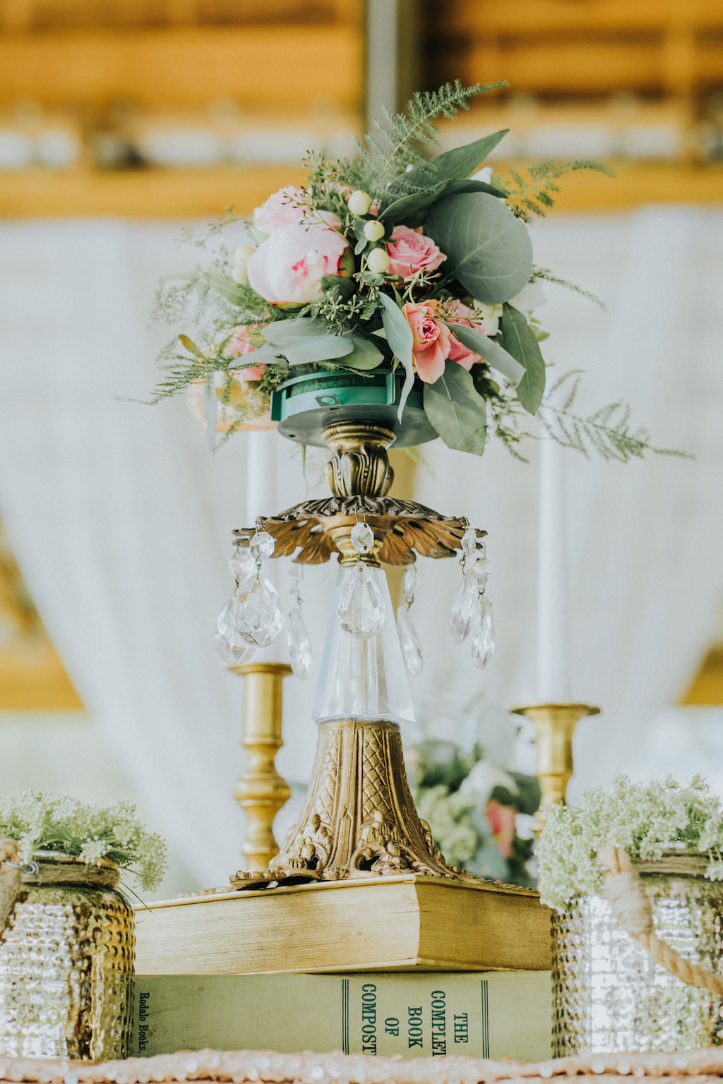 Elegant Rustic Wedding Reception Decor with Crystal and Brass Antique Vase Centerpiece with Pink Roses and Greenery, Old Books, and Mercury Vases with Succulents | Elegant Rustic Wedding Reception Table Setting with Antique Gold Silverware and Painted Floral Plates, Hand-painted Leaf Place Card and Blue and Pink Menu, Blush Pink Napkin with Fern Napkin Ring | Sarasota Wedding Planner Kelly Kennedy Weddings and Events | Tampa Bay Wedding Rentals Ever After Vintage Weddings