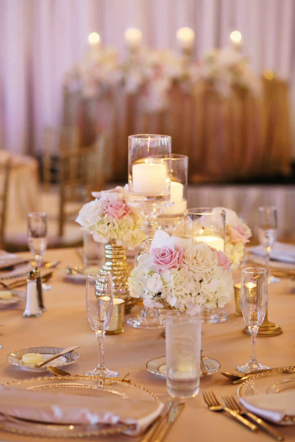 Short Small Wedding Reception Centerpieces with White Hydrangeas and Orchids, Blush Roses in Small Gold Vase with Glass Hurricane Candle Holders | St Petersburg Wedding Planner Parties A La Carte