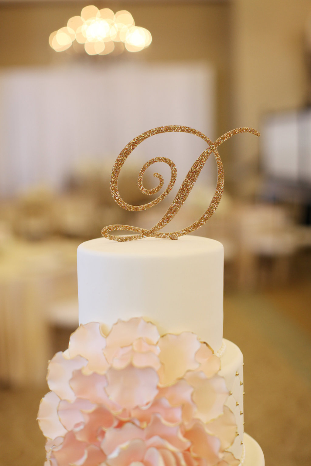 Stylish Gold Glitter Initial Cake topper on Round White Wedding Cake with Blush Floral Decor