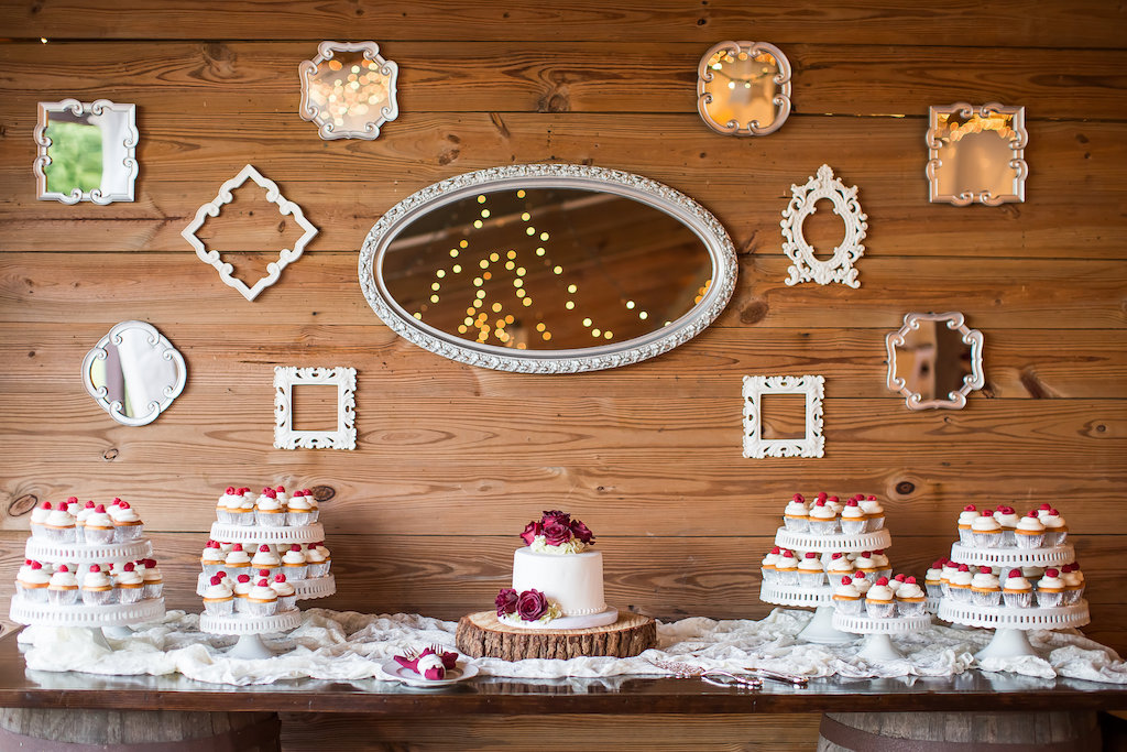 Red and White Farm Wedding Dessert Table with Round White Wedding Cake with Red Flowers on Natural Tree Ring Cake Stand with Tiered Cupcake Trays and Vintage Mismatched Mirrors | Tampa Bay Wedding Cake Baker Alessi Bakeries