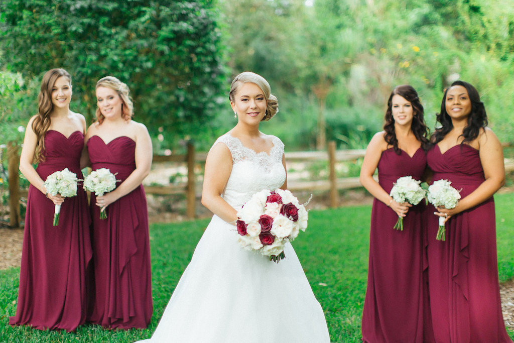 Outdoor Garden Bridal Party Portrait with Blush, Red, and Cream Rose Bouquet, Bridesmaids in Matching Strapless Marsala Dresses | Tampa Bay Wedding Photographer Rad Red Creative | Bridal Shop Truly Forever Bridal | Bella Bridesmaid