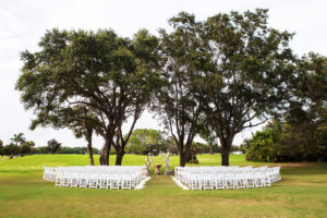Outdoor Ceremony With Natural Driftwood and Floral Arch and White Folding Chairs | Tampa Bay Wedding Venue Countryside Country Club