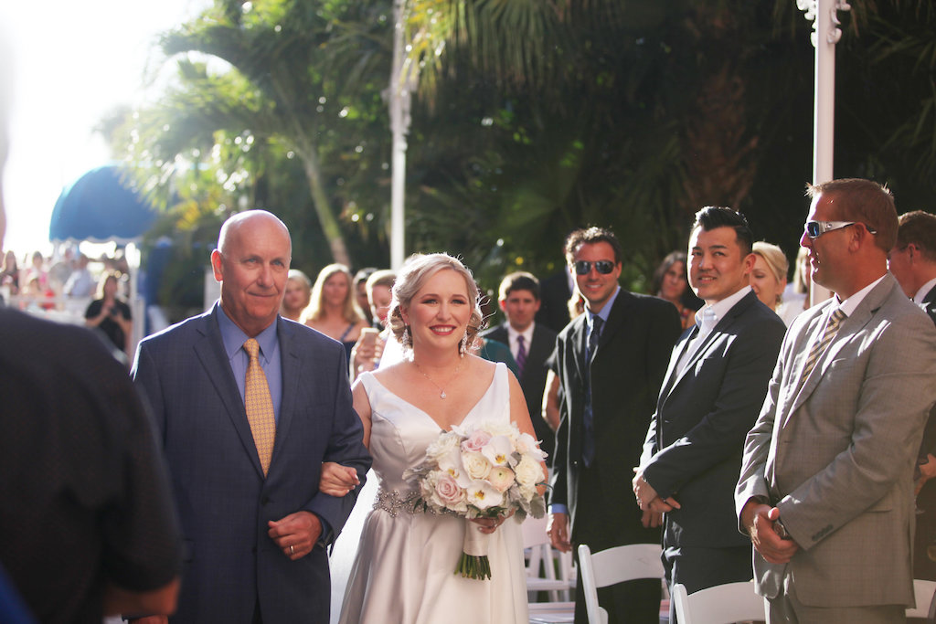 Outdoor Garden Ceremony Portrait with V Neck Wedding Dress and White Orchid and Blush Rose Bouquet with White Folding Chairs | St Pete Beach Wedding Venue The Don CeSar