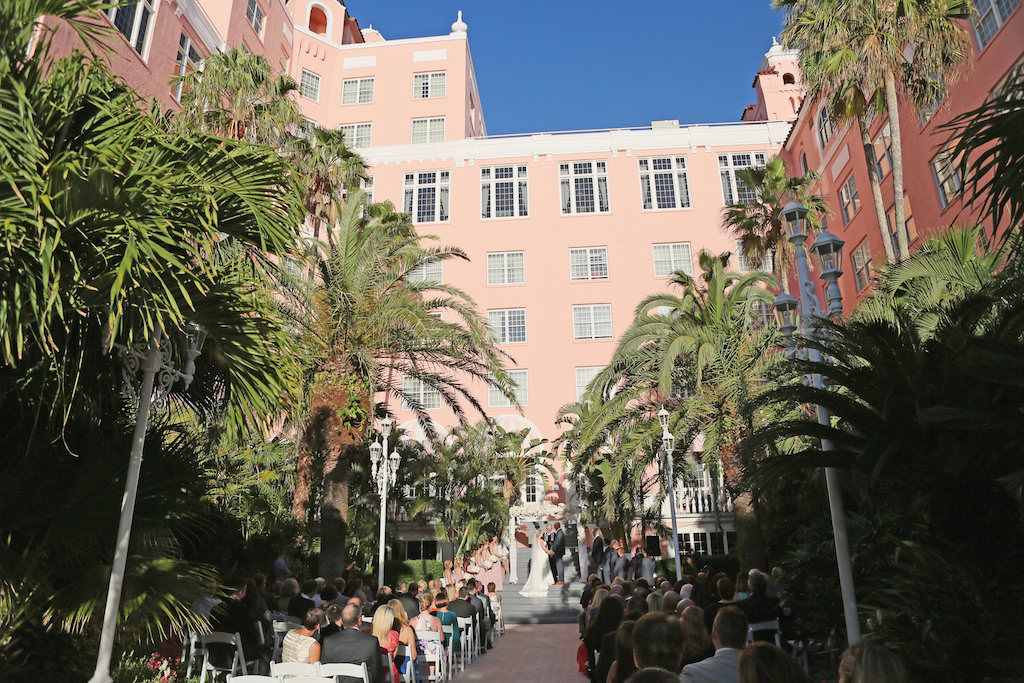 Outdoor Garden Ceremony Portrait with White Floral Arch with White Folding Chairs | St Pete Beach Wedding Venue The Don CeSar